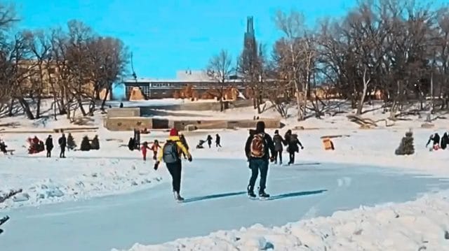 People skating down the Red River Trail in Winnipeg near the Forks.