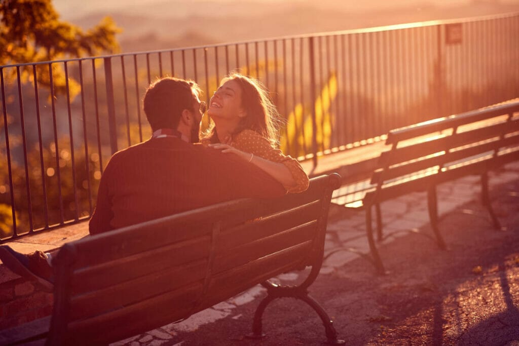 An image of a woman and a man laughing at an intimate joke while on a date.