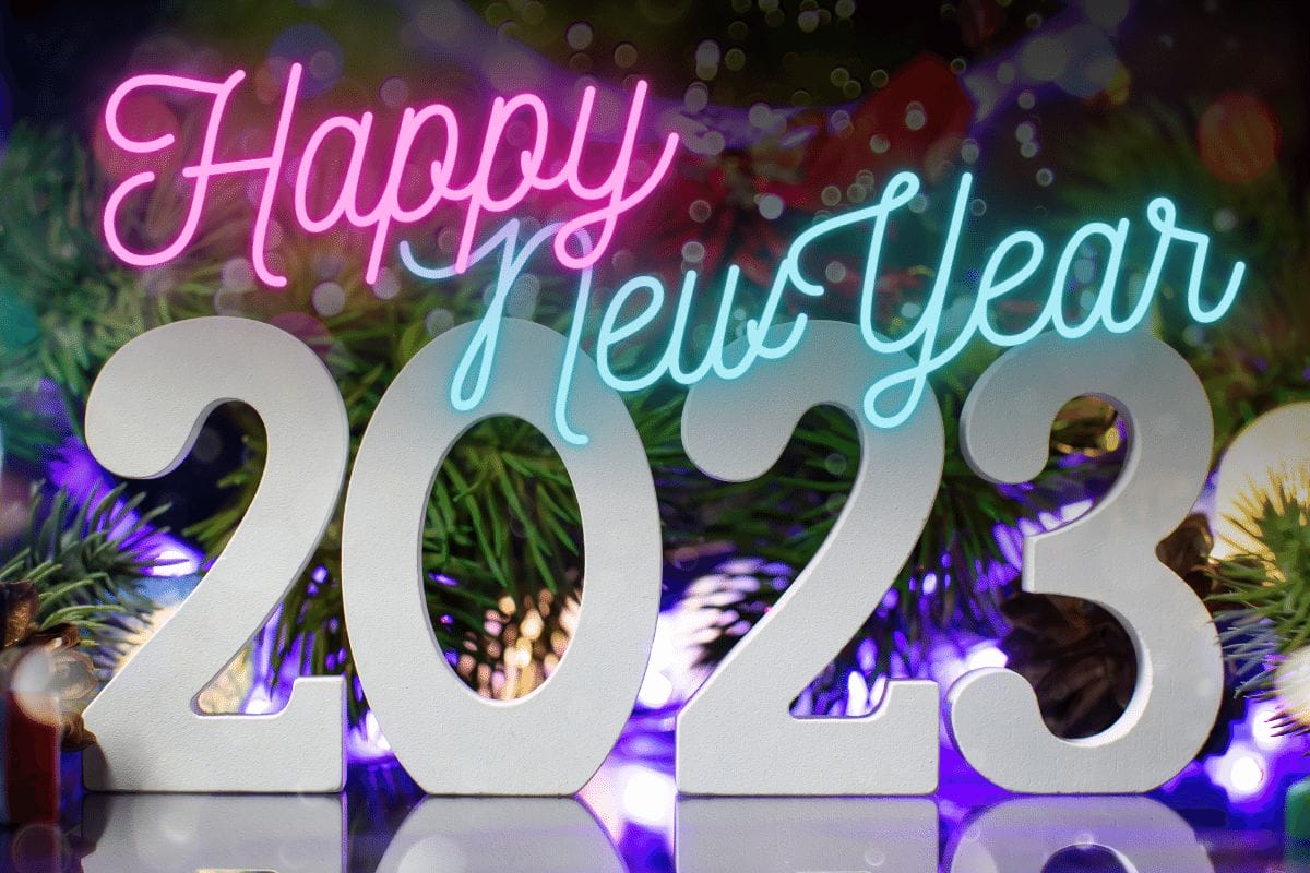 Happy New Year 2023 in front of some winter decorations.