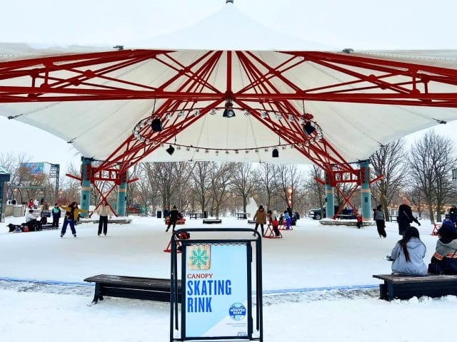Skaters skating in the Canopy Skating Rink at the Forks on a cold winter's day
