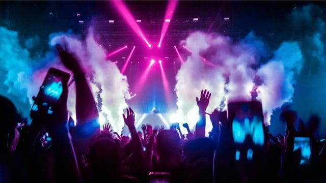Hands up at an EDM festival with smoke from the stage for Summer of Sound