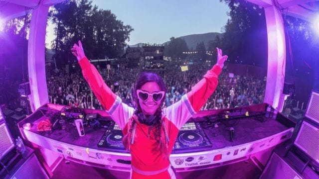DJ with her hands up in front of a crowd at the MEME festival