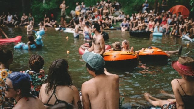 People Relaxing on Floating Rafts on a River at Rainbow Trout Music Festival